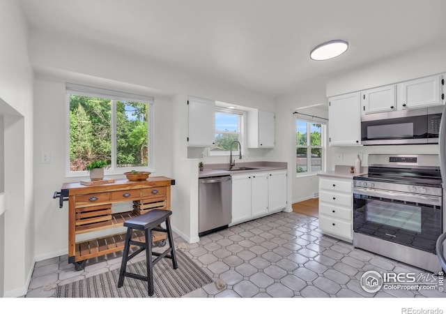 2036 Lexington Ct, Fort Collins, CO 80526 - kitchen featuring appliances with stainless steel finishes, white cabinetry, and light countertops