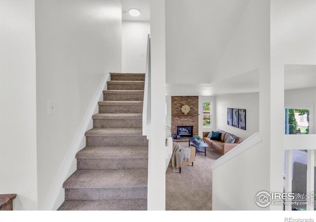 2036 Lexington Ct, Fort Collins, CO 80526 - staircase featuring carpet, a fireplace, plenty of natural light, and a towering ceiling