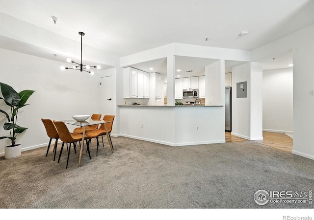 530 Mohawk Dr Unit 73, Boulder, CO 80303 - kitchen with light carpet, appliances with stainless steel finishes, a chandelier, white cabinetry, and electric panel