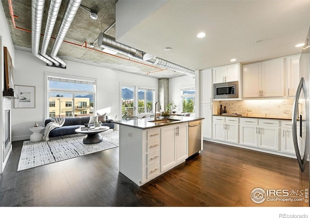 3401 Arapahoe Ave Unit 420, Boulder, CO 80303 - kitchen featuring appliances with stainless steel finishes, dark wood-style flooring, dark countertops, open floor plan, and recessed lighting