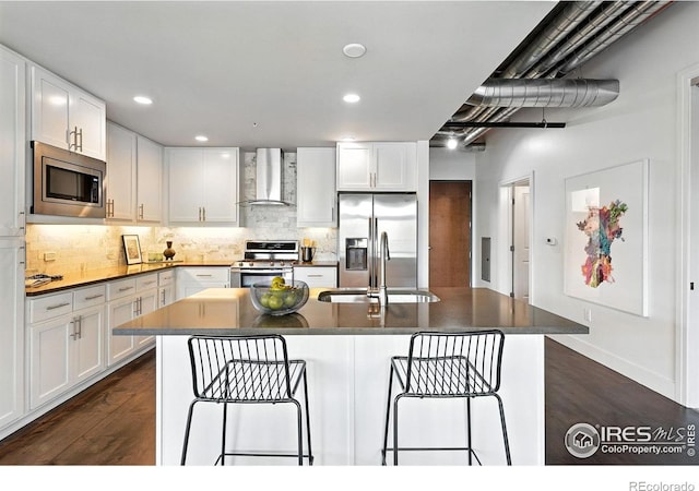 3401 Arapahoe Ave Unit 420, Boulder, CO 80303 - kitchen with appliances with stainless steel finishes, wall chimney exhaust hood, dark wood-type flooring, a breakfast bar area, and recessed lighting