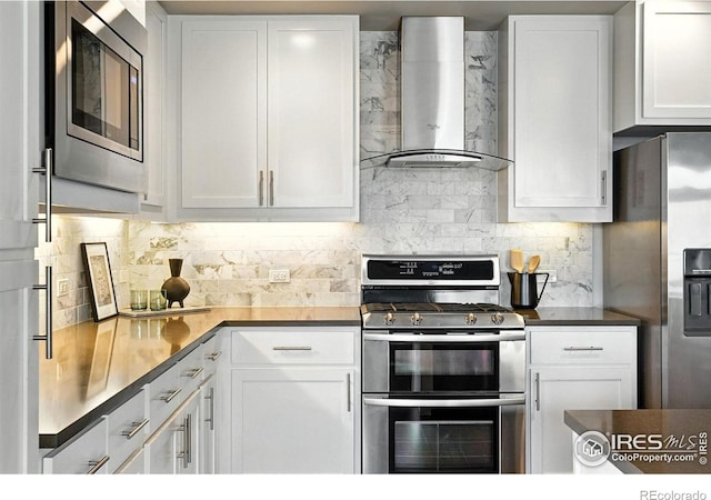 3401 Arapahoe Ave Unit 420, Boulder, CO 80303 - kitchen featuring wall chimney range hood, appliances with stainless steel finishes, white cabinetry, and decorative backsplash