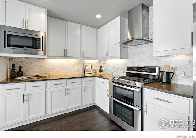 3401 Arapahoe Ave Unit 420, Boulder, CO 80303 - kitchen featuring stainless steel appliances, wall chimney exhaust hood, dark countertops, white cabinetry, and recessed lighting