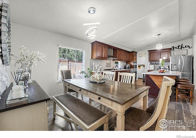 2036 1st Ave Unit 437, Greeley, CO 80631 - dining room featuring dark wood finished floors, vaulted ceiling, a textured ceiling, and ornamental molding