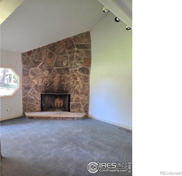 1550 W 28th St Unit 1, Loveland, CO 80538 - unfurnished living room featuring lofted ceiling, carpet floors, and a stone fireplace