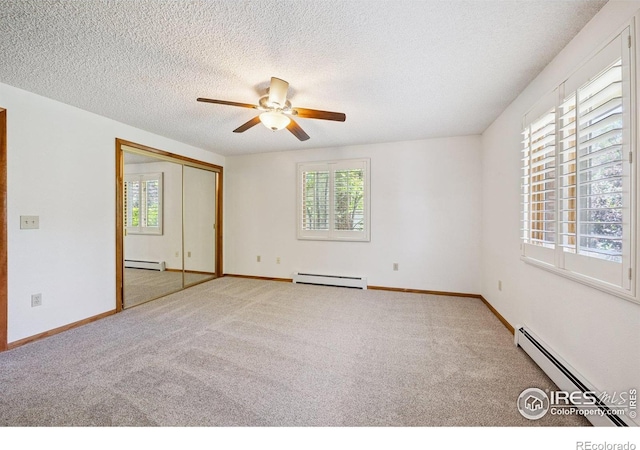 2513 Lanyon Dr, Longmont, CO 80503 - carpeted spare room with a baseboard heating unit, a baseboard radiator, plenty of natural light, and a textured ceiling