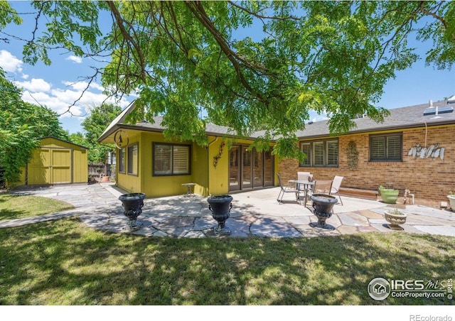 2513 Lanyon Dr, Longmont, CO 80503 - rear view of house with a storage shed, a patio area, a lawn, and brick siding