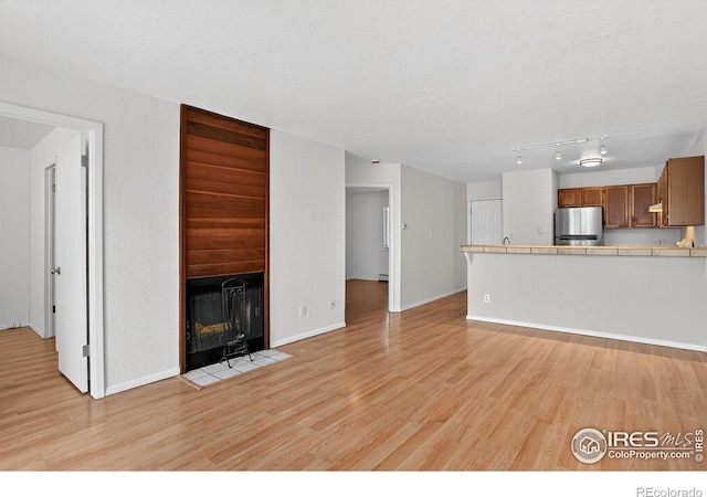 3535 28th St # 202, Boulder, CO 80301 - unfurnished living room with a fireplace with flush hearth, light wood-style flooring, and a textured ceiling