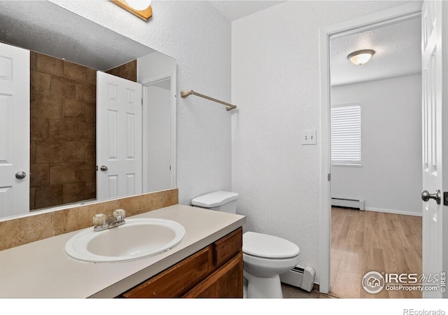 3535 28th St # 202, Boulder, CO 80301 - bathroom featuring a baseboard radiator, vanity, wood finished floors, and a textured wall