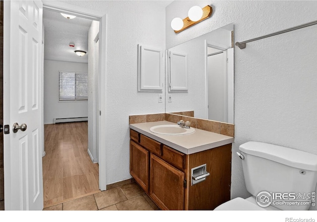 3535 28th St # 202, Boulder, CO 80301 - half bathroom featuring baseboard heating, vanity, and a textured wall