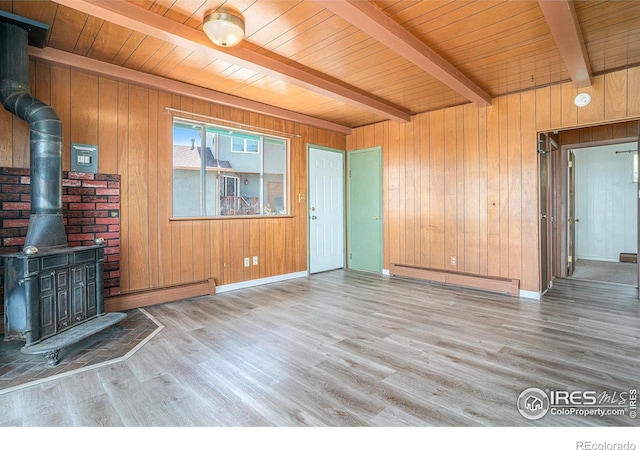 5017 Overhill Dr, Fort Collins, CO 80526 - unfurnished living room with a baseboard heating unit, a wood stove, wood walls, wood finished floors, and a wood ceiling with exposed beams