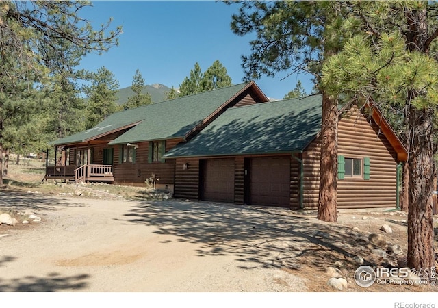 30795 W Ridge Rd, Buena Vista, CO 81211 - log home featuring dirt driveway, a shingled roof, an attached garage, and faux log siding