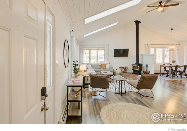 30795 W Ridge Rd, Buena Vista, CO 81211 - living room featuring a wood stove, high vaulted ceiling, plenty of natural light, wood finished floors, and ceiling fan
