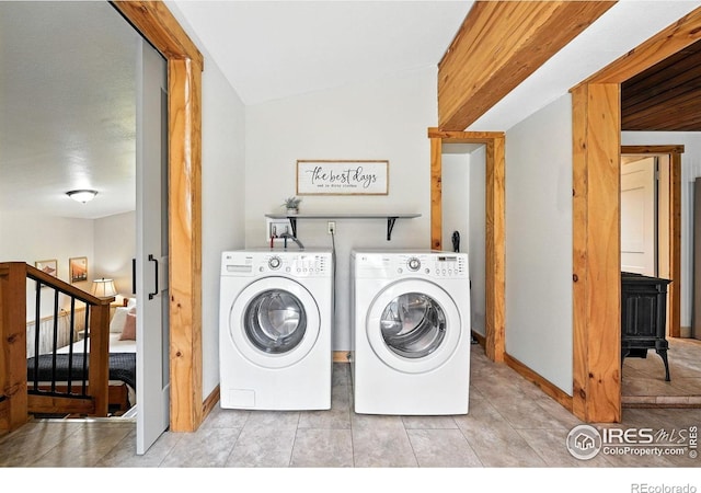181 County Road 874, Tabernash, CO 80478 - laundry area featuring a wood stove, washer and clothes dryer, and tile patterned floors