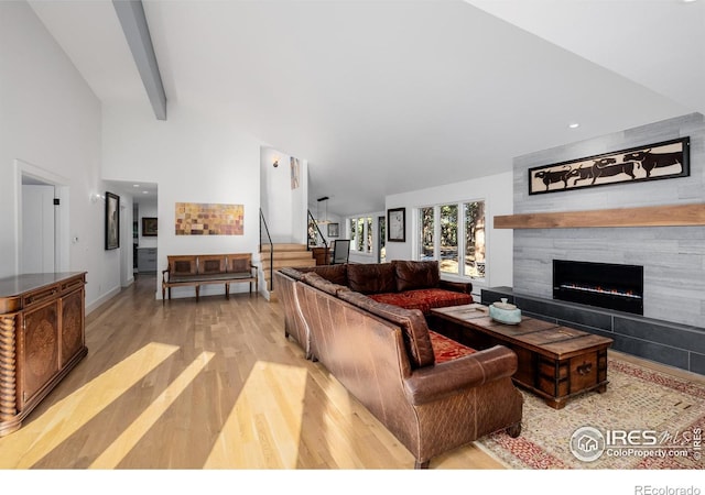 37 Wagner Cir, Boulder, CO 80304 - living area featuring stairway, light wood finished floors, a fireplace, and high vaulted ceiling