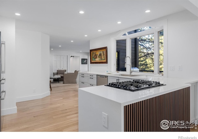 37 Wagner Cir, Boulder, CO 80304 - kitchen with light wood-style floors, gas stovetop, stainless steel dishwasher, recessed lighting, and white cabinetry