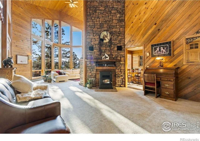 451 Newell Dr, Loveland, CO 80537 - living room with high vaulted ceiling, wooden walls, wooden ceiling, carpet flooring, and a fireplace