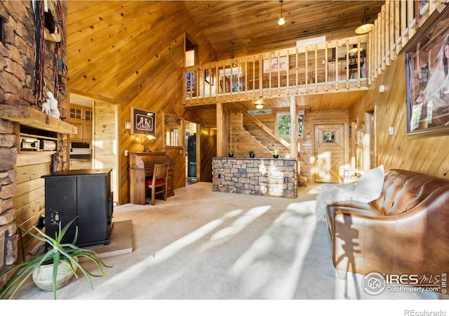 451 Newell Dr, Loveland, CO 80537 - carpeted living room with wood walls, wooden ceiling, high vaulted ceiling, and a wood stove