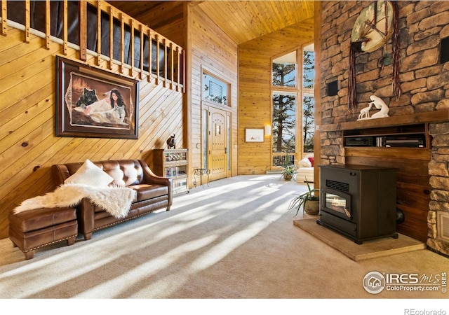 451 Newell Dr, Loveland, CO 80537 - living room featuring wood ceiling, carpet flooring, wood walls, a wood stove, and lofted ceiling