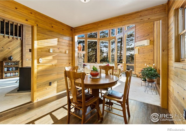451 Newell Dr, Loveland, CO 80537 - dining area with wood walls, an AC wall unit, and wood-type flooring