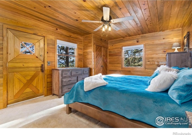 451 Newell Dr, Loveland, CO 80537 - carpeted bedroom with multiple windows, wood walls, wood ceiling, and ceiling fan