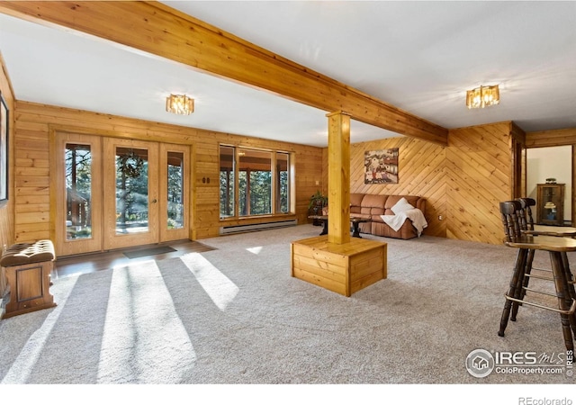 451 Newell Dr, Loveland, CO 80537 - living room featuring wood walls, healthy amount of natural light, a baseboard heating unit, beam ceiling, and carpet floors