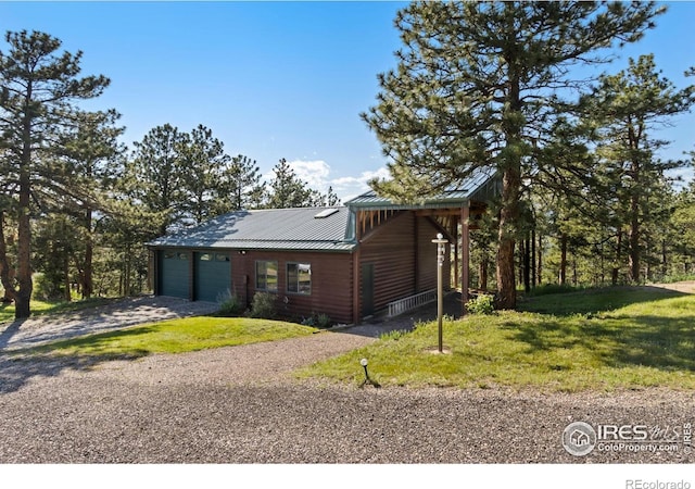 451 Newell Dr, Loveland, CO 80537 - rustic home with gravel driveway, a garage, a standing seam roof, and a front yard