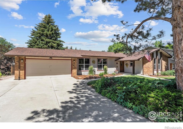 607 42nd Ave, Greeley, CO 80634 - view of front of house with brick siding, an attached garage, and concrete driveway
