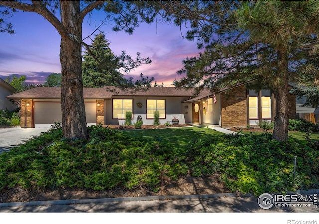 607 42nd Ave, Greeley, CO 80634 - view of front of house with an attached garage, concrete driveway, a front yard, and brick siding