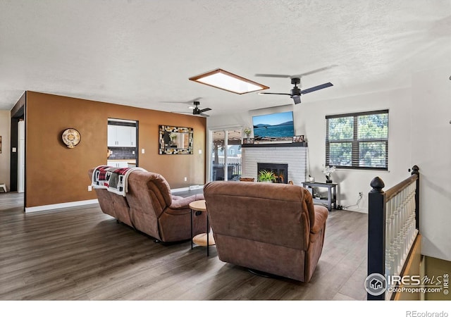 607 42nd Ave, Greeley, CO 80634 - living area featuring a ceiling fan, wood finished floors, a brick fireplace, and a textured ceiling