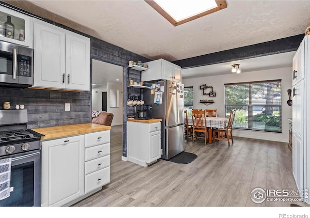 607 42nd Ave, Greeley, CO 80634 - kitchen featuring appliances with stainless steel finishes, wood counters, white cabinets, and light wood-type flooring