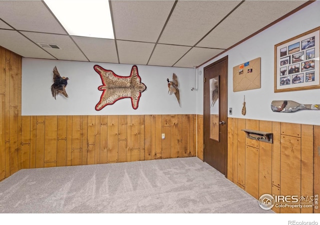 607 42nd Ave, Greeley, CO 80634 - empty room featuring wooden walls, a wainscoted wall, carpet floors, and a drop ceiling