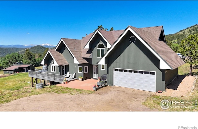 4815 Sugarloaf Rd, Boulder, CO 80302 - view of front of house with dirt driveway, a garage, a deck with mountain view, and roof with shingles