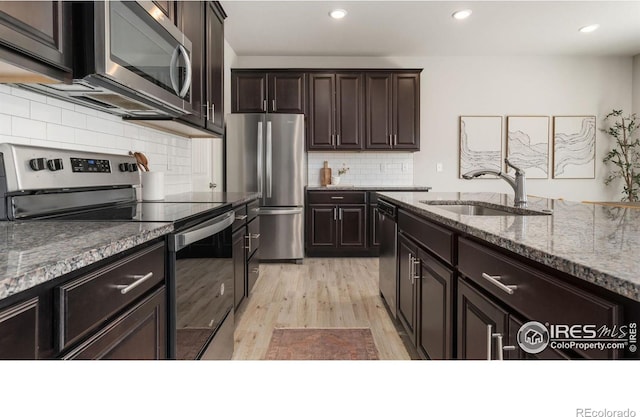 2742 Cooperland Blvd, Berthoud, CO 80513 - kitchen with appliances with stainless steel finishes, light wood-style floors, decorative backsplash, stone counters, and recessed lighting