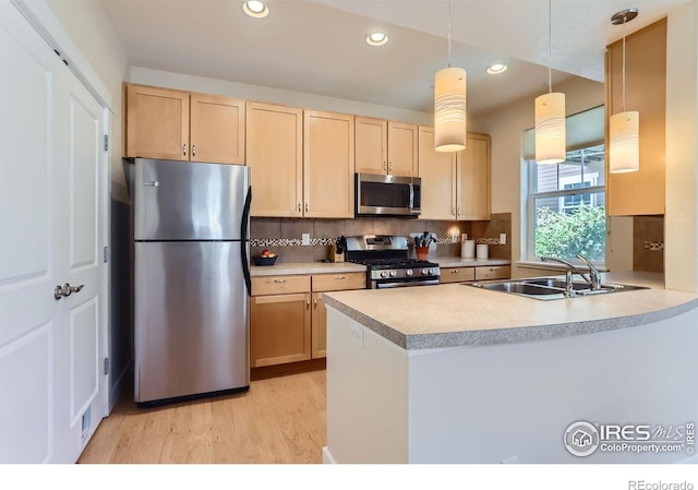 193 2nd Ave Unit A, Lyons, CO 80540 - kitchen featuring stainless steel appliances, light brown cabinets, light wood-type flooring, a peninsula, and decorative backsplash