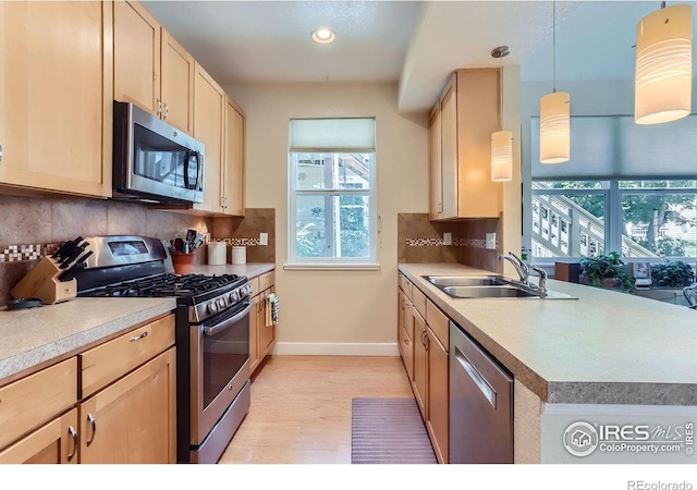 193 2nd Ave Unit A, Lyons, CO 80540 - kitchen with stainless steel appliances, light brown cabinets, light wood-style floors, decorative backsplash, and recessed lighting