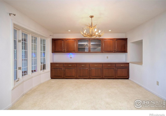 7035 S Boulder Rd, Boulder, CO 80303 - kitchen with a chandelier, light colored carpet, glass insert cabinets, hanging light fixtures, and brown cabinetry