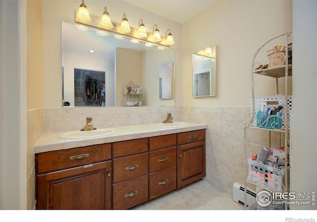 7035 S Boulder Rd, Boulder, CO 80303 - bathroom with tile walls, baseboard heating, double vanity, tile patterned flooring, and wainscoting