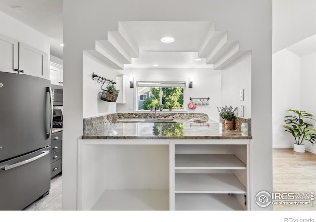 1993 S Fork Dr, Lafayette, CO 80026 - kitchen with appliances with stainless steel finishes, dark stone counters, white cabinets, open shelves, and recessed lighting