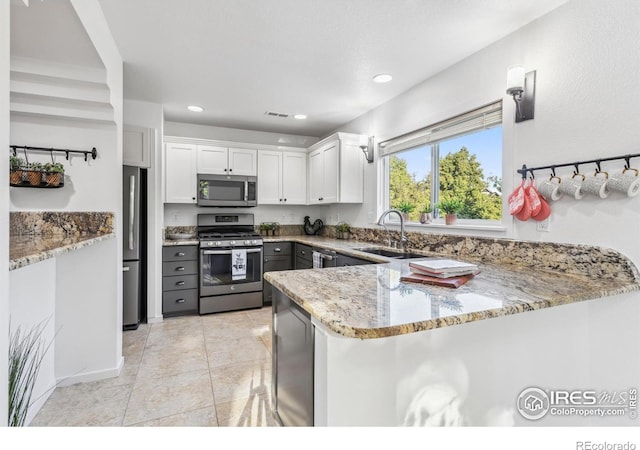1993 S Fork Dr, Lafayette, CO 80026 - kitchen featuring stainless steel appliances, light stone countertops, a peninsula, white cabinets, and recessed lighting