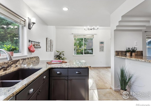 1993 S Fork Dr, Lafayette, CO 80026 - kitchen with light stone countertops, a peninsula, recessed lighting, and light tile patterned floors