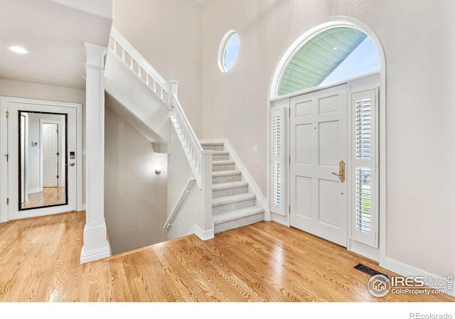 388 Fairfield Ln, Louisville, CO 80027 - entryway with wood finished floors, stairway, and ornate columns