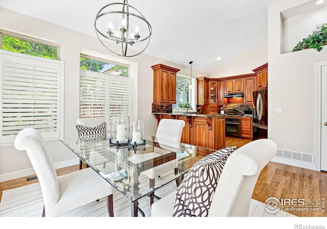 388 Fairfield Ln, Louisville, CO 80027 - dining area with a chandelier, light wood finished floors, and vaulted ceiling