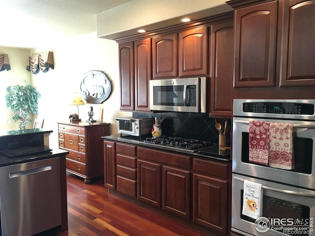 1402 Westfield Dr, Fort Collins, CO 80526 - kitchen featuring stainless steel appliances, dark wood-style flooring, dark countertops, and tasteful backsplash