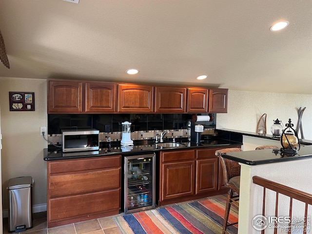 1402 Westfield Dr, Fort Collins, CO 80526 - kitchen featuring beverage cooler, stainless steel microwave, dark countertops, brown cabinetry, and recessed lighting