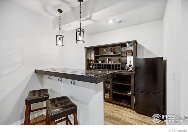 660 Cimarron Trl, Ault, CO 80610 - indoor dry bar with freestanding refrigerator, light wood-style flooring, and hanging light fixtures