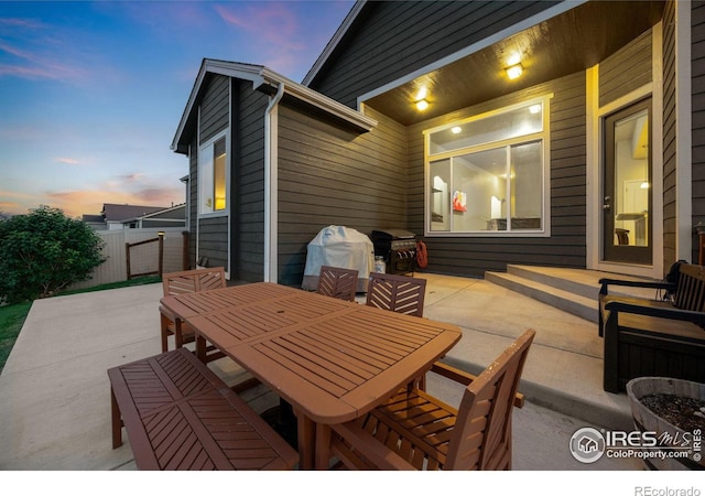 660 Cimarron Trl, Ault, CO 80610 - patio terrace at dusk featuring a patio, grilling area, and outdoor dining space