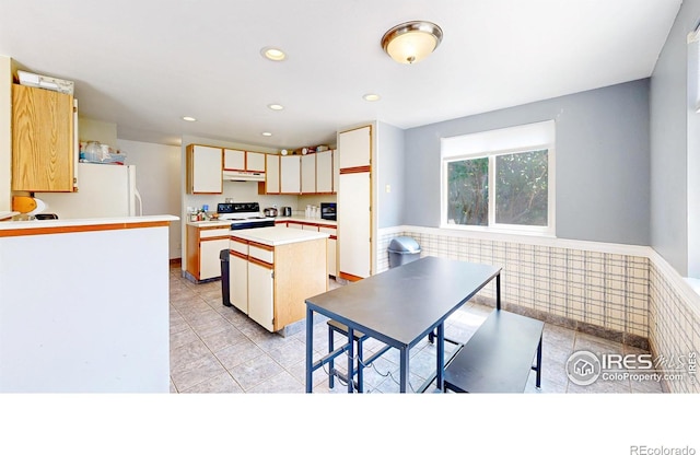 2027 Churchill Ct, Fort Collins, CO 80526 - kitchen featuring under cabinet range hood, freestanding refrigerator, a center island, light countertops, and recessed lighting