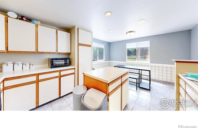 2027 Churchill Ct, Fort Collins, CO 80526 - kitchen featuring a wainscoted wall, white cabinetry, light countertops, light tile patterned floors, and recessed lighting