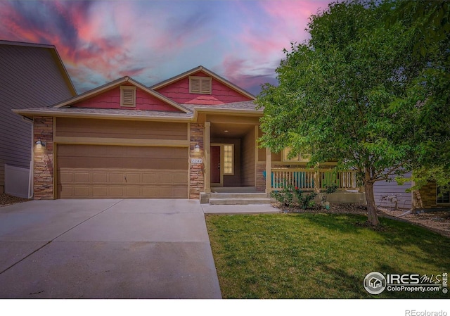 2244 Woodbury Ln, Fort Collins, CO 80524 - view of front of property featuring covered porch, driveway, an attached garage, a front lawn, and stone siding